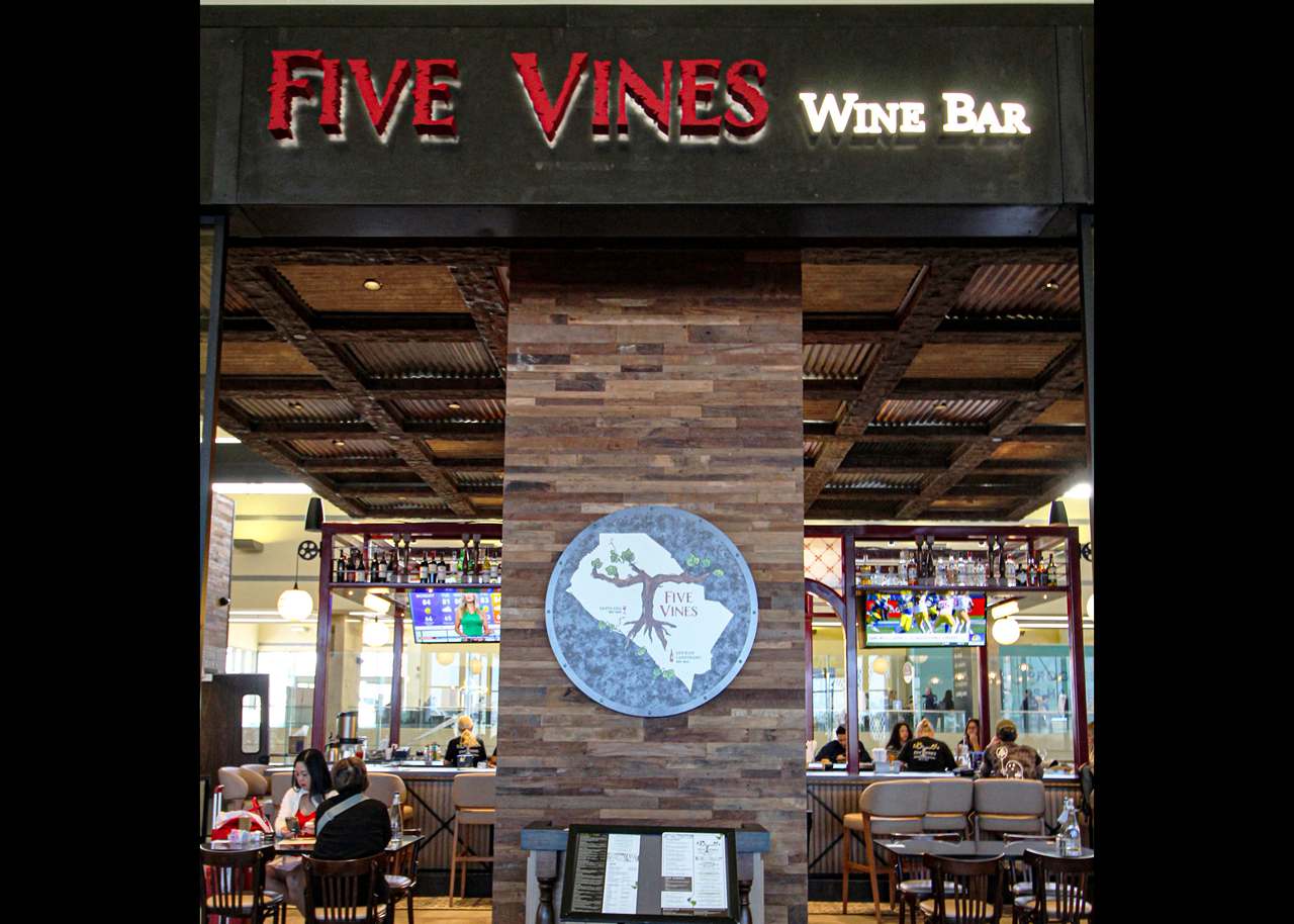 Five Vines wine bar sign and logo on storefront in the airport