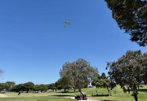 airplane flying over golf course
