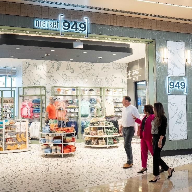 Airport travelers walking by a storefront