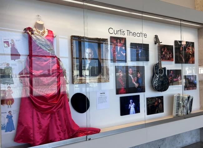Curtis Theatre display featuring images and items from Gentleman’s Guide to Love and Murder and Once