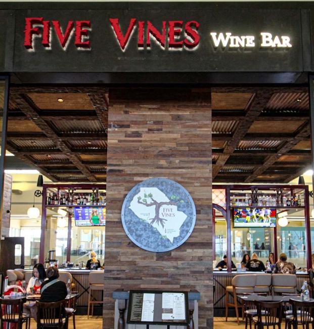 Five Vines wine bar sign and logo on storefront in the airport
